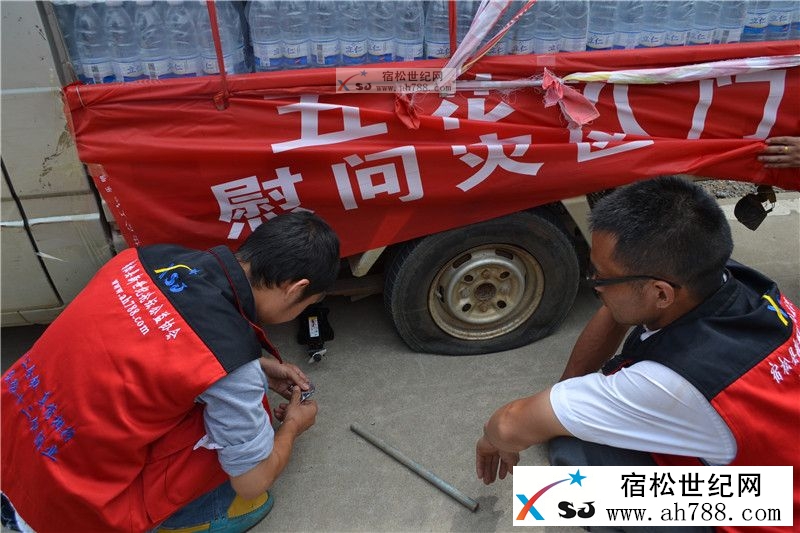 途中车辆爆胎，我们的会员在冒着酷暑换胎
